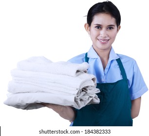 Smiling young cleaning lady holding towels isolated on white