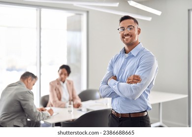 Smiling young confident Latin business man manager standing arms crossed at office team meeting. Portrait of happy professional businessman, male company employee leader in board room. - Powered by Shutterstock