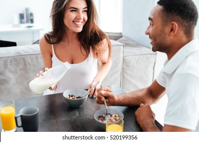 Smiling young couple having breakfast on the kitchen at home స్టాక్ ఫోటో