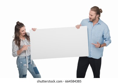 Smiling Young Couple Holding Blank White Card And Pointing At Copy Space