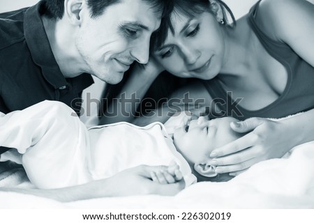 Similar – Mother reading book to her sons in the bed