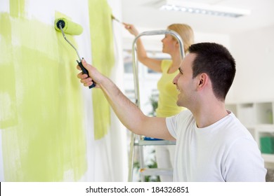 Smiling Young Couple  Painting Home 