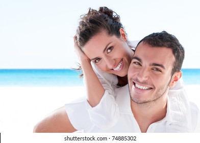 Smiling Young Couple Piggyback At Beautiful Summer Beach