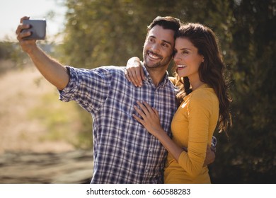 Smiling young couple taking selfie together at olive farm - Powered by Shutterstock