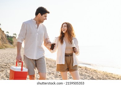 Smiling Young Couple Two Friend Family Man Woman In White Clothes Drink Beer Hold Picnic Bag Refrigerator Rest Together At Sunrise Over Sea Beach Ocean Outdoor Seaside In Summer Day Sunset Evening.