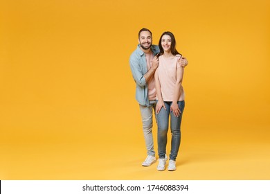 Smiling Young Couple Two Friends Guy Girl In Pastel Blue Casual Clothes Posing Isolated On Yellow Wall Background Studio Portrait. People Lifestyle Concept. Mock Up Copy Space. Hugging Looking Camera