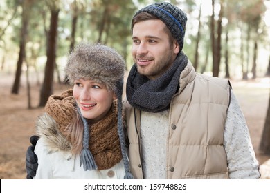 Smiling  young couple in winter clothing in the woods