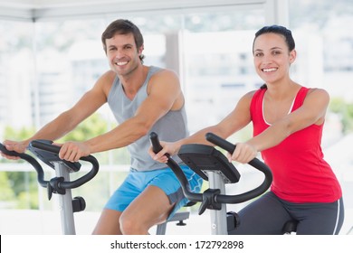 Smiling Young Couple Working Out At Class In A Bright Gym