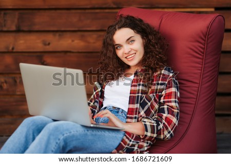 Smiling young curly woman working at home while quarantine. Distance studying