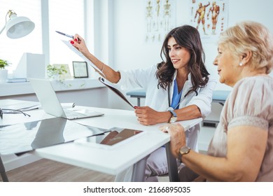 Smiling Young Doctor Having A Medical Exam. Shot Of A Middle Aged Female Doctor Sitting In Front Of Laptop And Consulting With Her Patient. Doctor And Her Patient