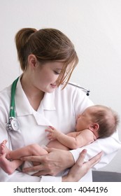 Smiling Young Doctor Holding A Beautiful Newborn Baby.