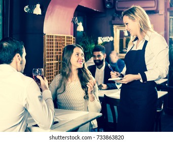 Smiling Young Family Having Date In Middle Class Restaurant. Focus On Blonde Girl