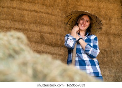 Smiling Young Farmer Looking At The Camera With Pitchfork In Her Hand