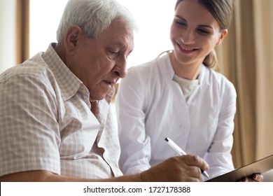 Smiling Young Female Doctor Or Caregiver Visit Senior Male Client Close Deal At Home, Positive Woman Medical Worker Consult Mature Man Sign Insurance Contract, Offer Help, Elderly Healthcare Concept