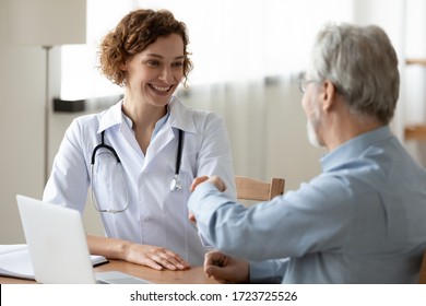 Smiling young female doctor handshaking greeting healthy senior male patient in hospital. Happy practitioner shake hand of elder client at advice meeting. Old people medical health care trust concept. - Powered by Shutterstock