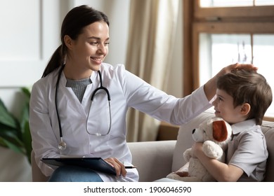 Smiling young female doctor or pediatrician talk comfort small boy patient at consultation in private clinic. Caring woman GP support cheer little kid examine consult in hospital. Healthcare concept.