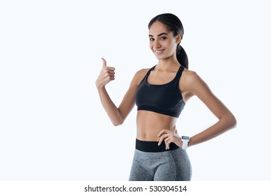 Smiling young female showing right thumb - Powered by Shutterstock