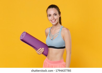 Smiling Young Fitness Sporty Woman Girl In Sportswear Posing Working Out Isolated On Yellow Wall Background Studio Portrait. Workout Sport Motivation Concept. Mock Up Copy Space. Hold Yoga Mat