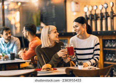 Smiling young friends drinking craft beer in pub - Powered by Shutterstock