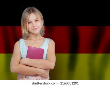 Smiling young girl with book against German flag background. Education and school in Germany concept. 