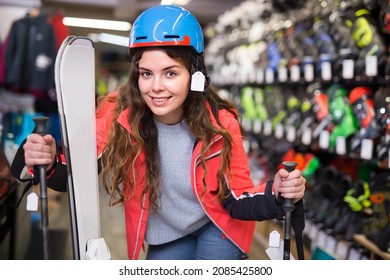 Smiling Young Girl Chose Skis, Shelm And Boots In A Sports Equipment Store