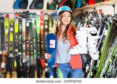 Smiling Young Girl Chose Skis, Shelm And Boots In A Sports Equipment Store