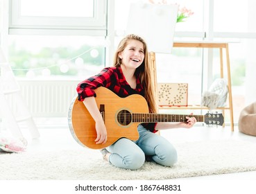 Lächelndes junges Mädchen mit Gitarre