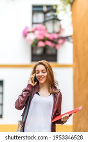 Smiling Young Girl Talking On Her Smartphone While Studying Abroad In Seville Spain