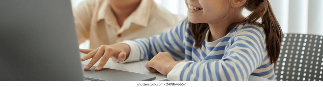 Smiling Young Girl Using Laptop at Classroom Table - Powered by Shutterstock