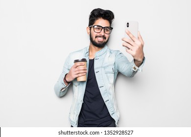 Smiling Young Guy Taking Selfie Photo On Smartphone. Indian Man Using Digital Device. Selfie Photo Concept. Isolated Front View On White Background.