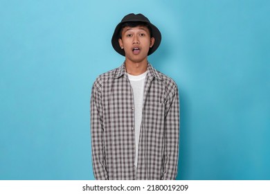 Smiling Young Handsome Asian Boy Using Flannel Shirt And Bucket Hat Standing Over Isolated Blue Background.