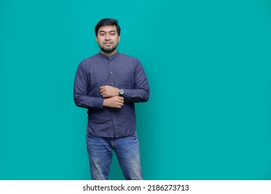 Smiling Young Handsome Southeast Asian Man Holding Clock In Studio Tosca
