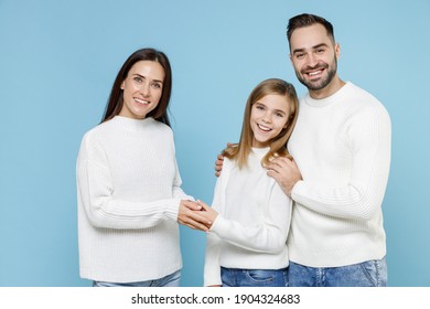 Smiling Young Happy Parents Mom Dad With Child Kid Daughter Teen Girl In Basic White Sweaters Hugging Holding Hands Isolated On Blue Color Background Studio Portrait. Family Day Parenthood Concept