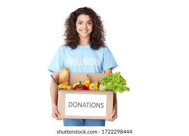 Smiling Young Hispanic Latin Woman Courier Wears Volunteer Tshirt Look At Camera Hold Social Donations Box Concept Delivering Grocery Food Delivery Stand Isolated On White Studio Background. Portrait.