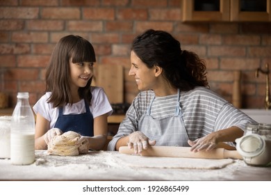 Smiling Young Hispanic Mom And Little Biracial Daughter Cook Delicious Cake Or Cookies At Home Kitchen. Happy Latino Mother And Small Girl Child Make Dough Bake Pastries Or Pie On Family Weekend.