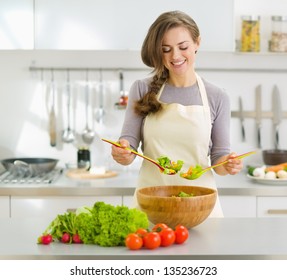 Smiling young housewife mixing fresh salad - Powered by Shutterstock