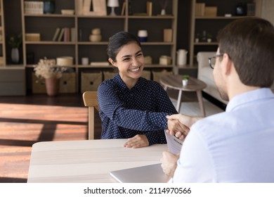 Smiling Young Indian Female Job Seeker Shaking Hands With Caucasian Hr Manager, Starting Interview Meeting Or Accepting Offer Proposal, Making Good First Impression Talking In Modern Office Room.