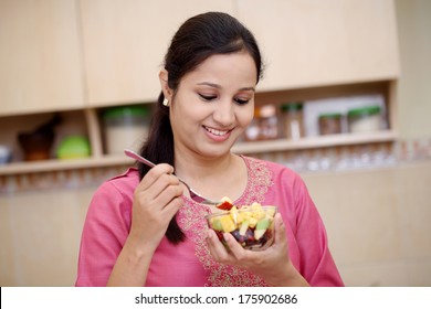 Smiling Young Indian Woman Eating Fruit Salad