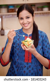 Smiling Young Indian Woman Eating Vegetable Salad