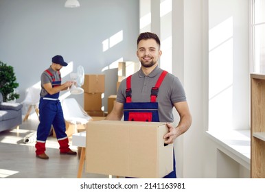 Smiling young male deliveryman or mover hold cardboard box pack belongings in client office or home. Happy man worker from removal or deliver company unload packages. Moving and relocation. - Shutterstock ID 2141163981