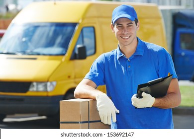 Smiling Young Male Postal Delivery Courier Man In Front Of Cargo Van Delivering Package