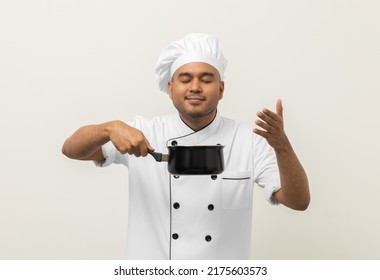 Smiling Young Man Chef In Uniform Gesture Smelling Empty Hot Pot Stew Soup Delicious Dish Menu Good Taste On Isolated. Cooking Man Occupation Chef People In Kitchen Restaurant And Hotel.