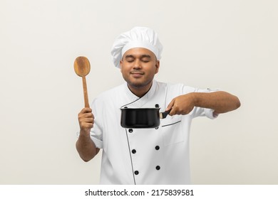 Smiling Young Man Chef In Uniform Gesture Smelling Empty Hot Pot Stew Soup Delicious Dish Menu Good Taste On Isolated. Cooking Man Occupation Chef People In Kitchen Restaurant And Hotel.