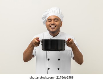 Smiling Young Man Chef In Uniform Gesture Smelling Empty Hot Pot Stew Soup Delicious Dish Menu Good Taste On Isolated. Cooking Man Occupation Chef People In Kitchen Restaurant And Hotel.