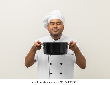 Smiling Young Man Chef In Uniform Gesture Smelling Empty Hot Pot Stew Soup Delicious Dish Menu Good Taste On Isolated. Cooking Man Occupation Chef People In Kitchen Restaurant And Hotel.