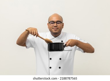 Smiling Young Man Chef In Uniform Gesture Smelling Empty Hot Pot Delicious Dish Menu Good Taste On Isolated. Cooking  Man Occupation Chef People In Kitchen Restaurant And Hotel.