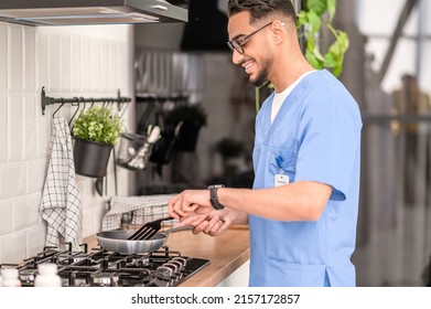 Smiling Young Man Cooking On The Gas Stove