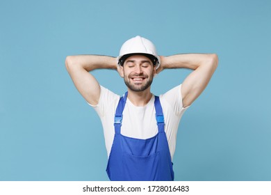 Smiling young man in coveralls protective helmet hardhat isolated pastel blue background  Instruments accessories for renovation apartment room  Repair home concept  Sleep and hands behind head