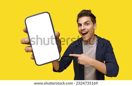 Smiling young man depicted holding big smartphone in hand, inviting viewer to take closer look. Smartphone's screen features white copy space, providing ample room for customized text or graphics