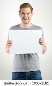 Smiling Young Man Holding Blank Sign In Hands